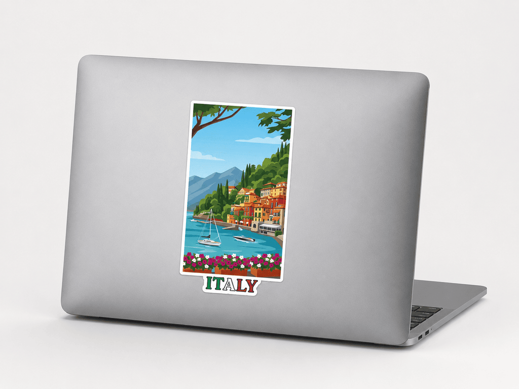 A silver laptop with a colorful travel-style illustration of a lakeside town and the word "ITALY" printed on the back, shown on a clean light gray background.