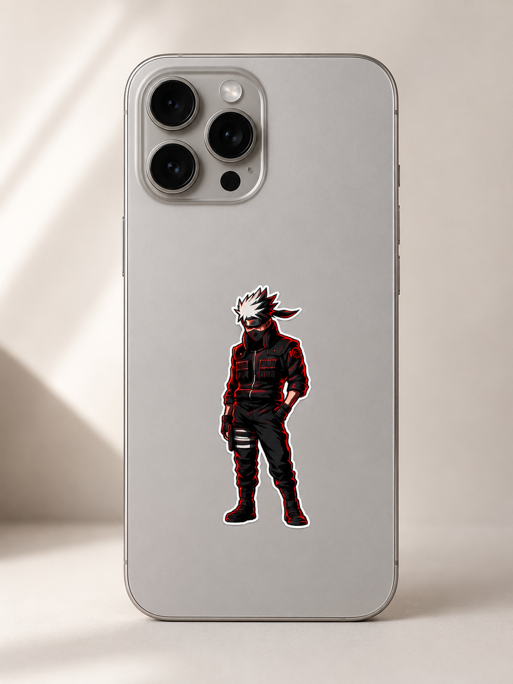 A silver phone case featuring a die-cut graphic of the anime character Kakashi Hatake, shown on a light beige background with soft shadows.