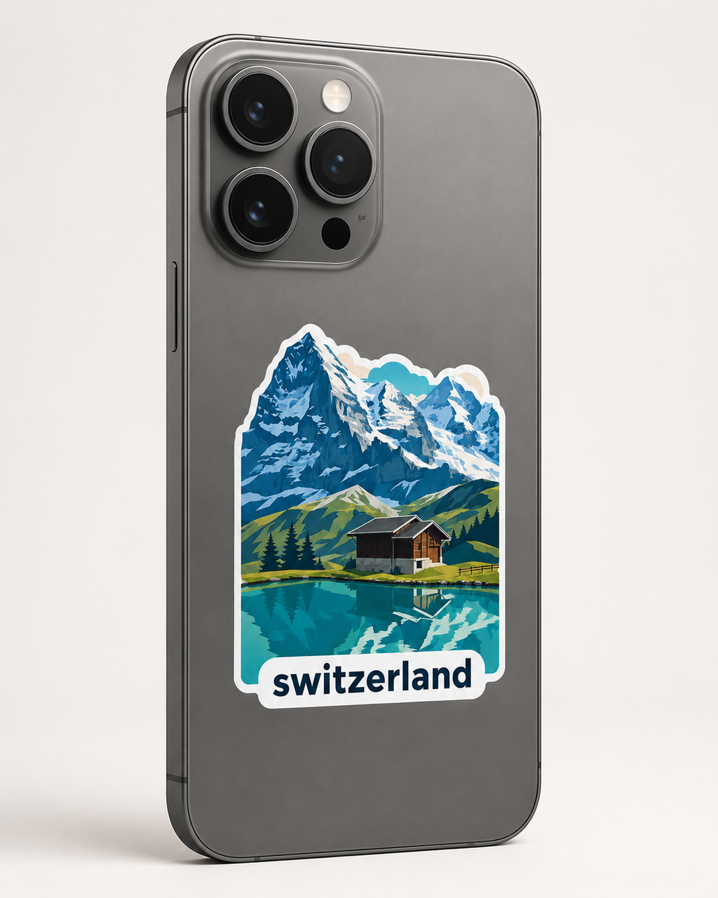 A dark gray smartphone case featuring a colorful retro-style illustration of a Swiss mountain landscape with a lake, cabin, and the word 'switzerland' printed below, shown on a phone against a light neutral background.